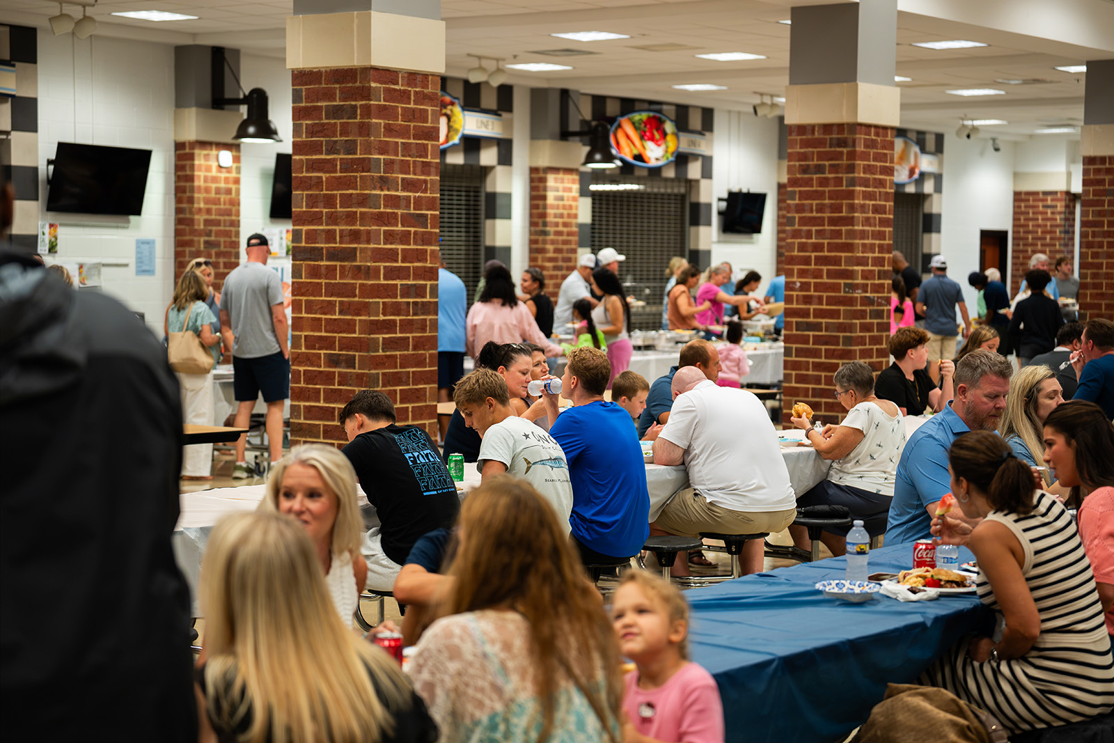 Families and players eating together in the packed school commons