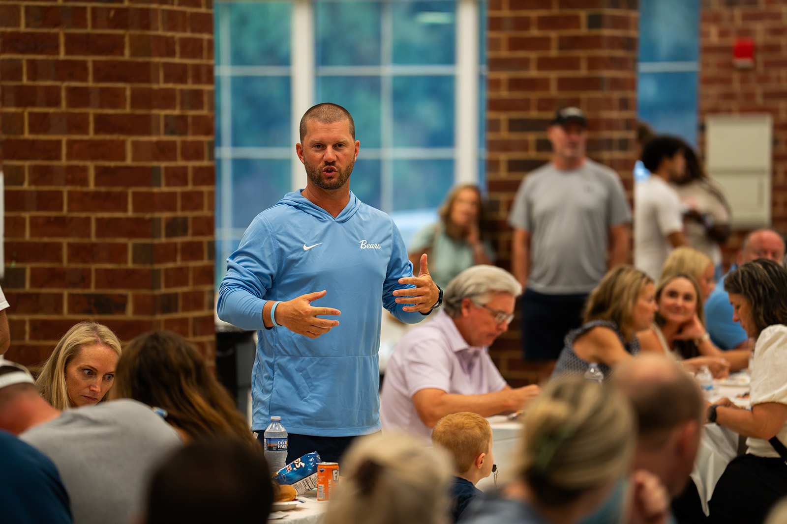 Head coach addressing players and families at the team dinner