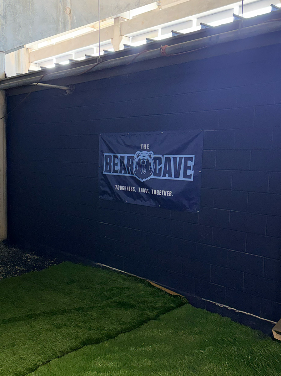 The Bear Cave banner - Toughness. Trust. Together. - hanging on the freshly painted navy wall
