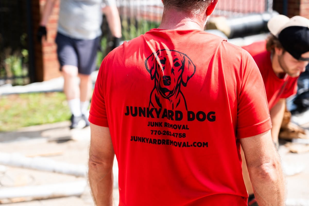 Junkyard Dog Junk Removal crew member helping haul away old equipment at the Bear Gridiron Club work day